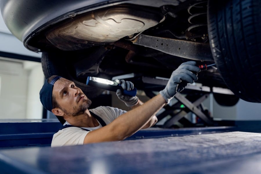 mechanic checking truck with flashlight